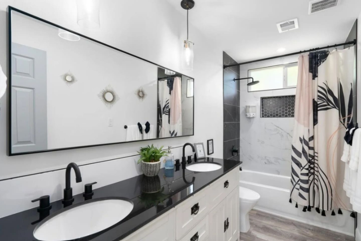 Spa-like primary bathroom with dual vanity, walk-in shower, and modern black and white finishes.