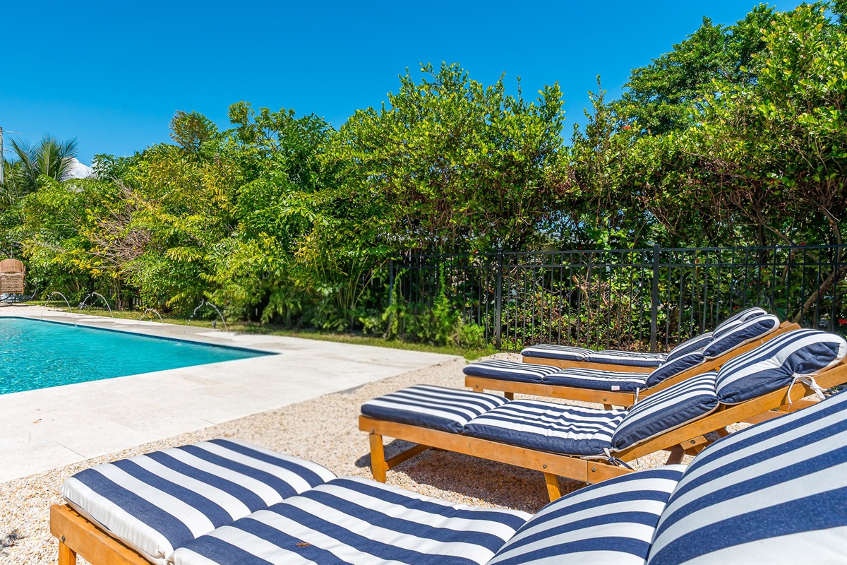 The pool deck is finished in shell white limestone, offering a beautiful natural backdrop.  By night, enjoy the tiki bar, TV, fire table, and the glow of the Jupiter Lighthouse Beacon 