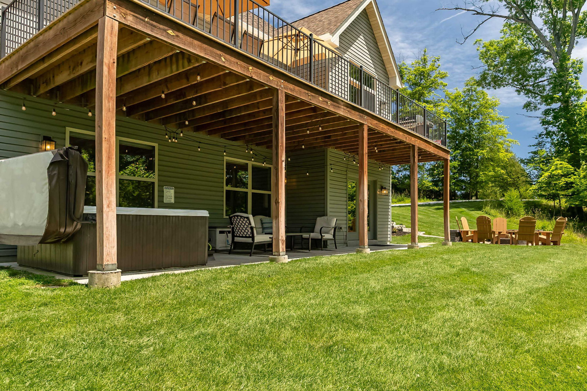 Covered outdoor living area with hot tub, dining, and lounge seating.