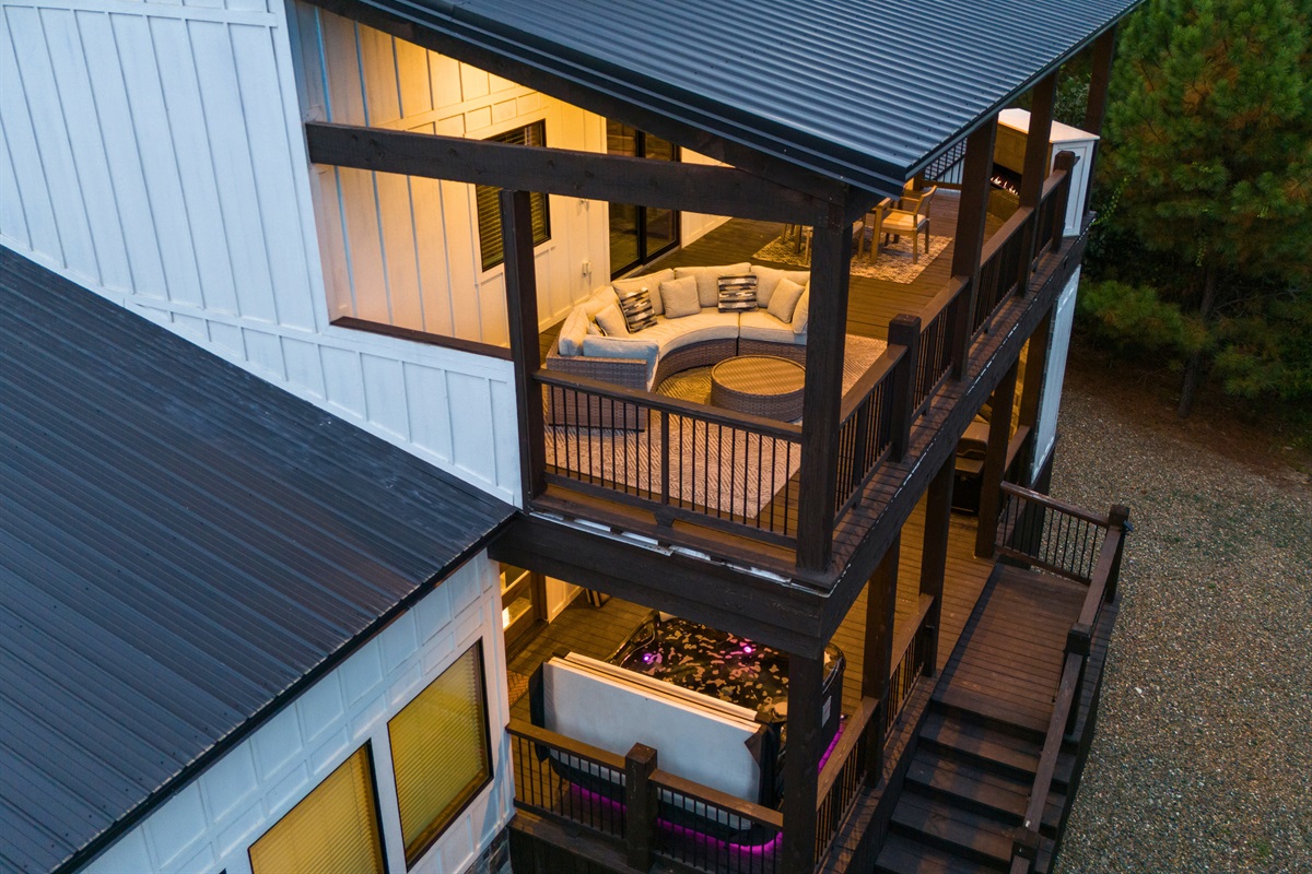 Modern two-story cabin with multiple decks and outdoor living areas.