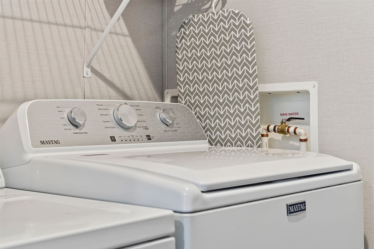 Modern washer setup with simple controls and nearby ironing essentials for added convenience.