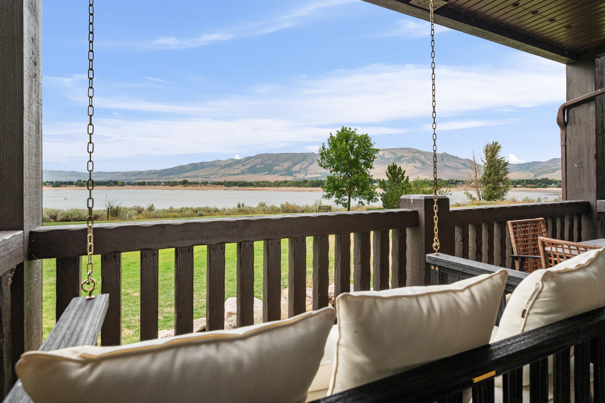 Covered balcony with comfortable seating and beautiful views of Pineview Reservoir and the surrounding mountains.