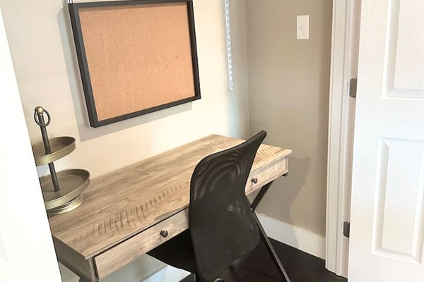 Tucked away for privacy, this dedicated workstation features a rustic wooden desk, an ergonomic mesh chair, and a handy corkboard. It is the perfect nook for catching up on emails or planning your daily itinerary before heading out to the sand.
