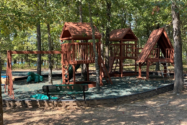 A play area nestled in the trees invites imagination and adventure for younger guests.