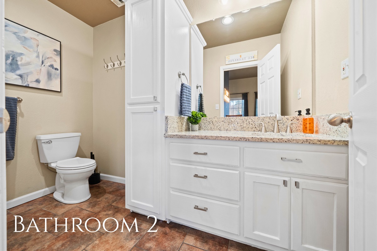 This bright bathroom features generous counter space and natural light, offering a comfortable and convenient place to get ready for the day or wind down at night.