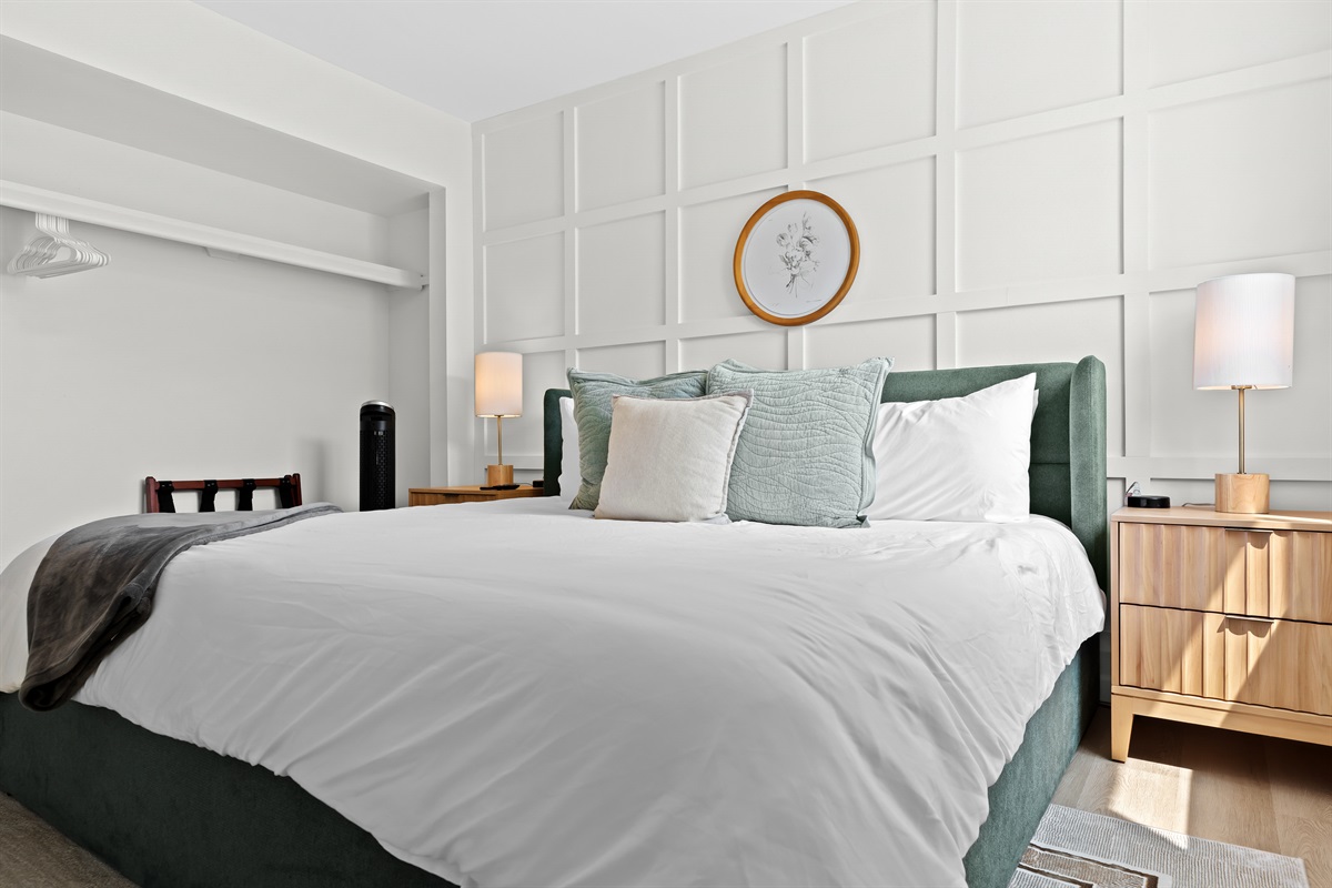 Sleep soundly in this serene bedroom featuring a king-size bed, ambient lighting, and stylish wood panel accent wall.