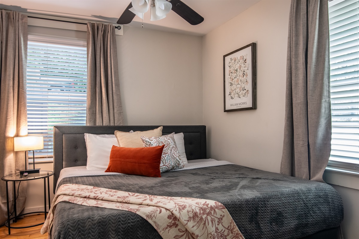 Spacious bedroom featuring a queen-sized bed, blackout curtains, and soft bedding for a restful night’s sleep.
