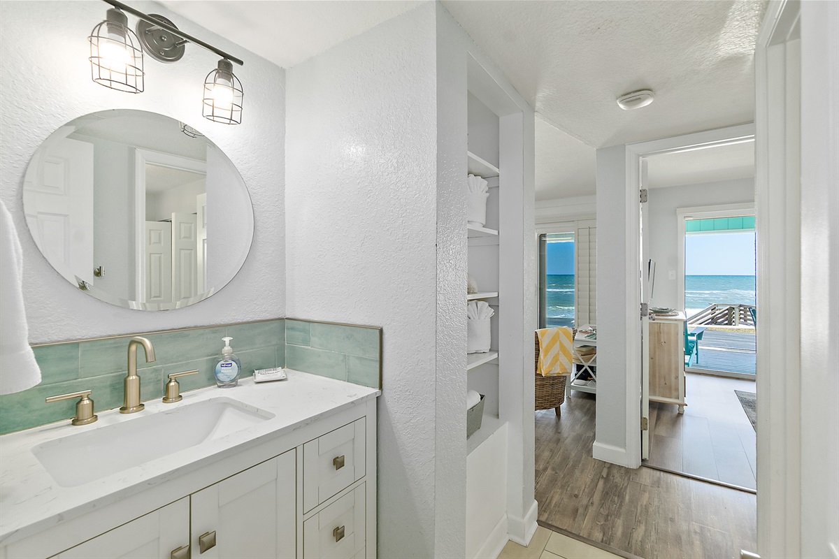 Bright bathroom with ocean view through the hallway