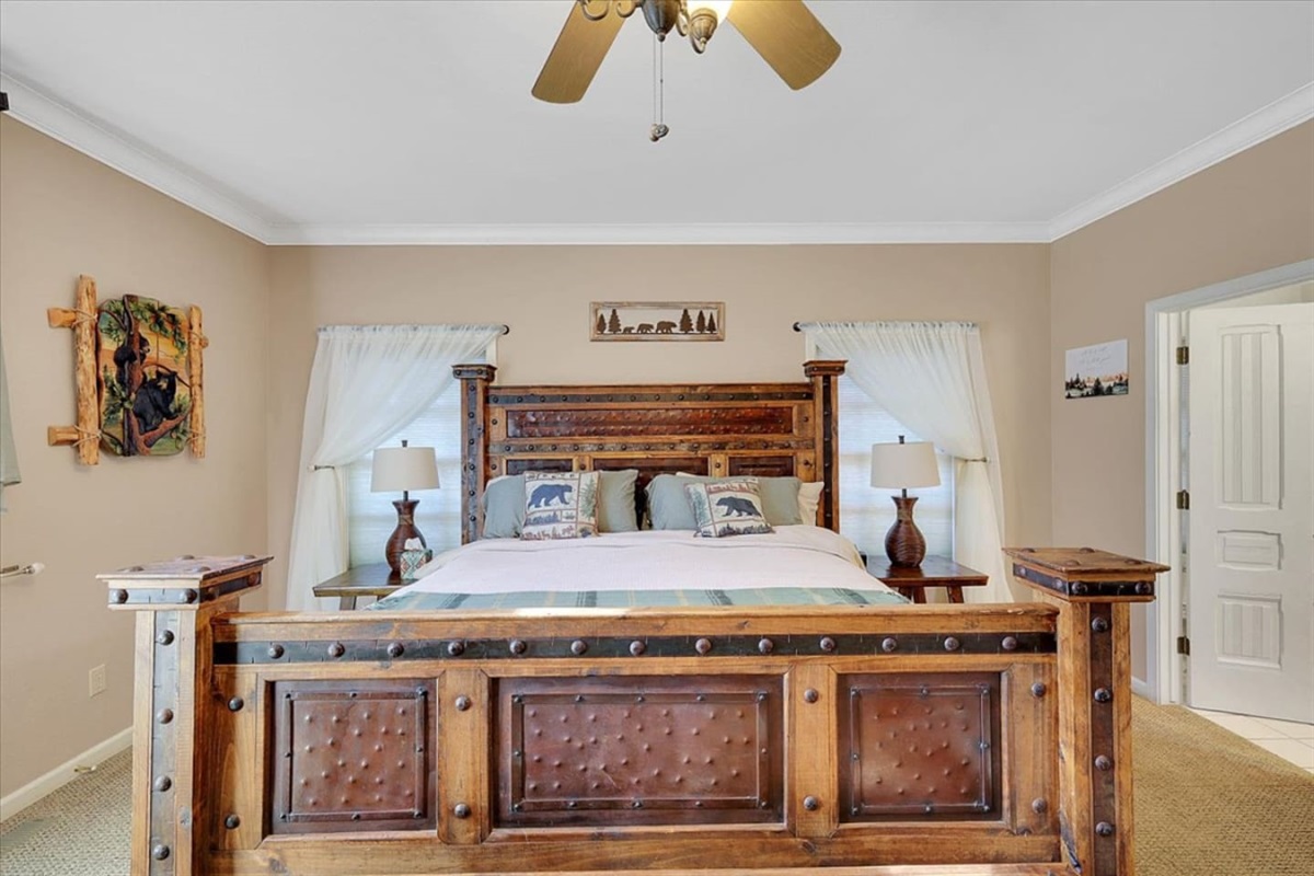 King bedroom with rustic wood furniture, bedside lamps, and a simple place to rest.
