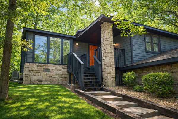 A striking corner view of the home's modern stone-and-wood exterior.