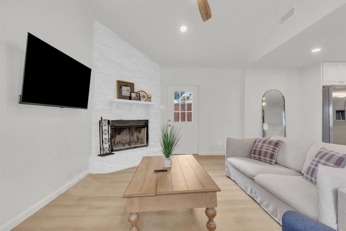 Spacious private living room featuring an indoor fireplace and comfortable seating—perfect for unwinding after a day at Grandscape or Topgolf.
