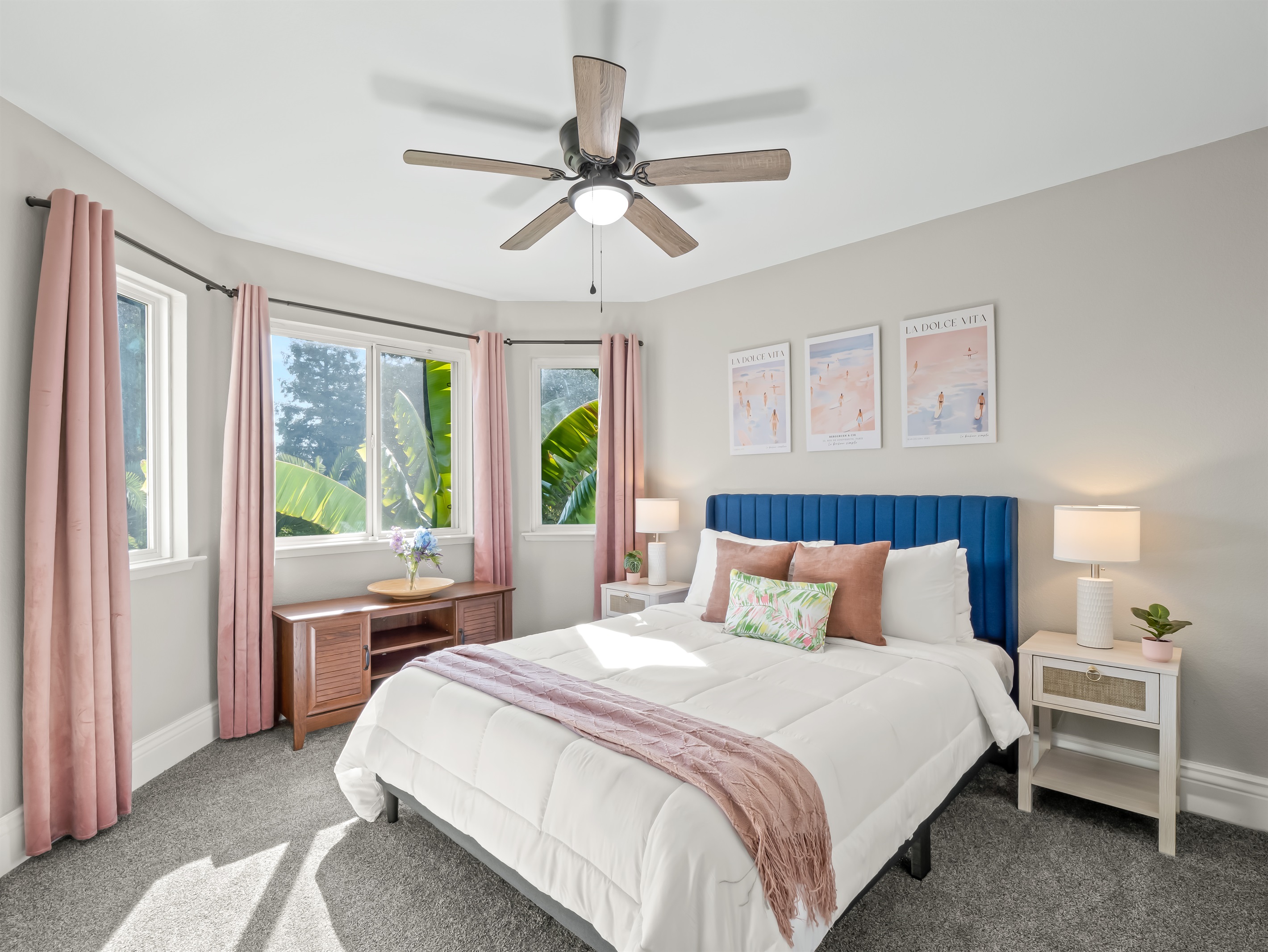 Bright, beautifully styled retreat featuring a statement headboard, designer accents, and sun-filled corner windows for a true vacation vibe.