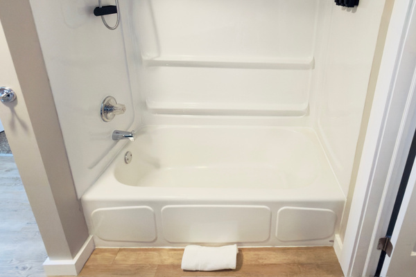 Primary bathroom vanity with open storage and fresh towels.