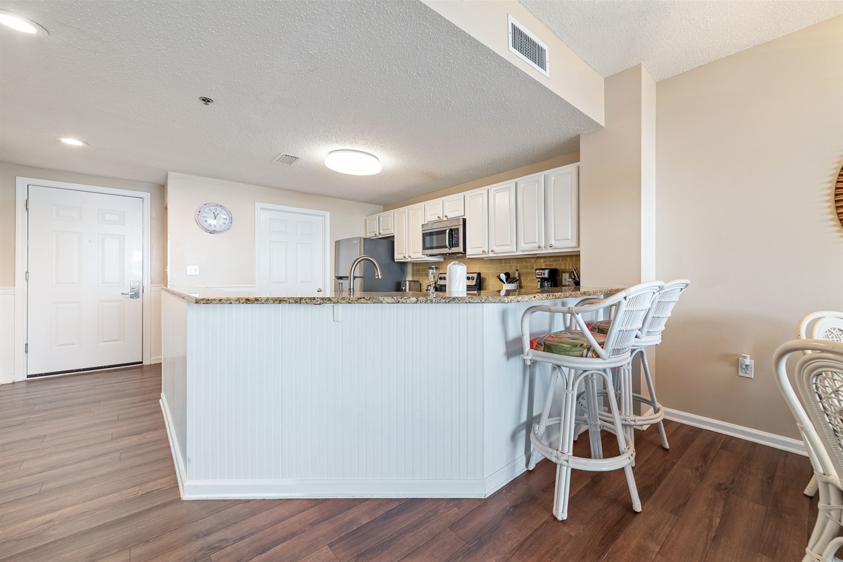 The kitchen island takes center stage, offering ample counter space and casual seating. Perfect for meal prep, entertaining, and everyday living.