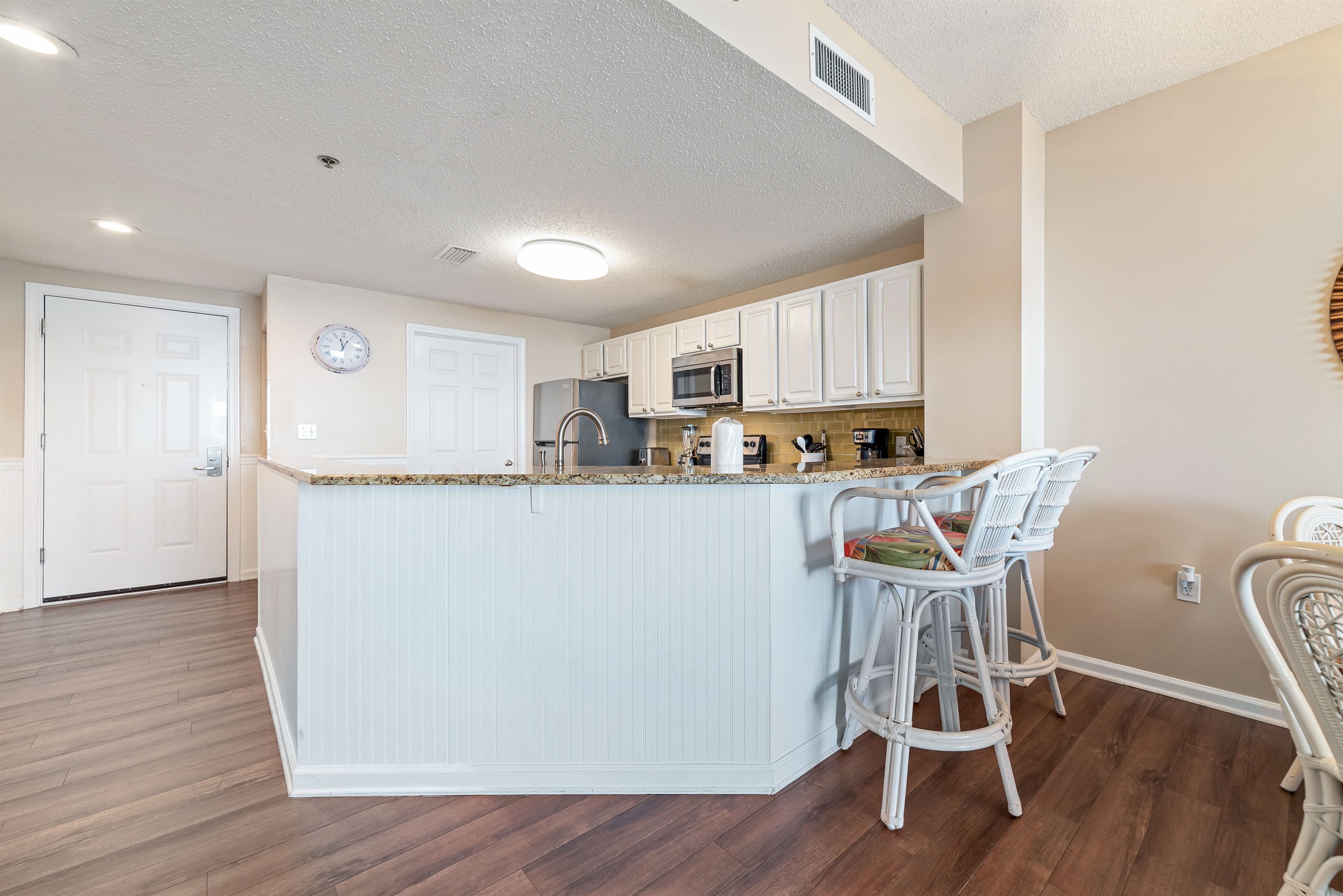 The kitchen island takes center stage, offering ample counter space and casual seating. Perfect for meal prep, entertaining, and everyday living.
