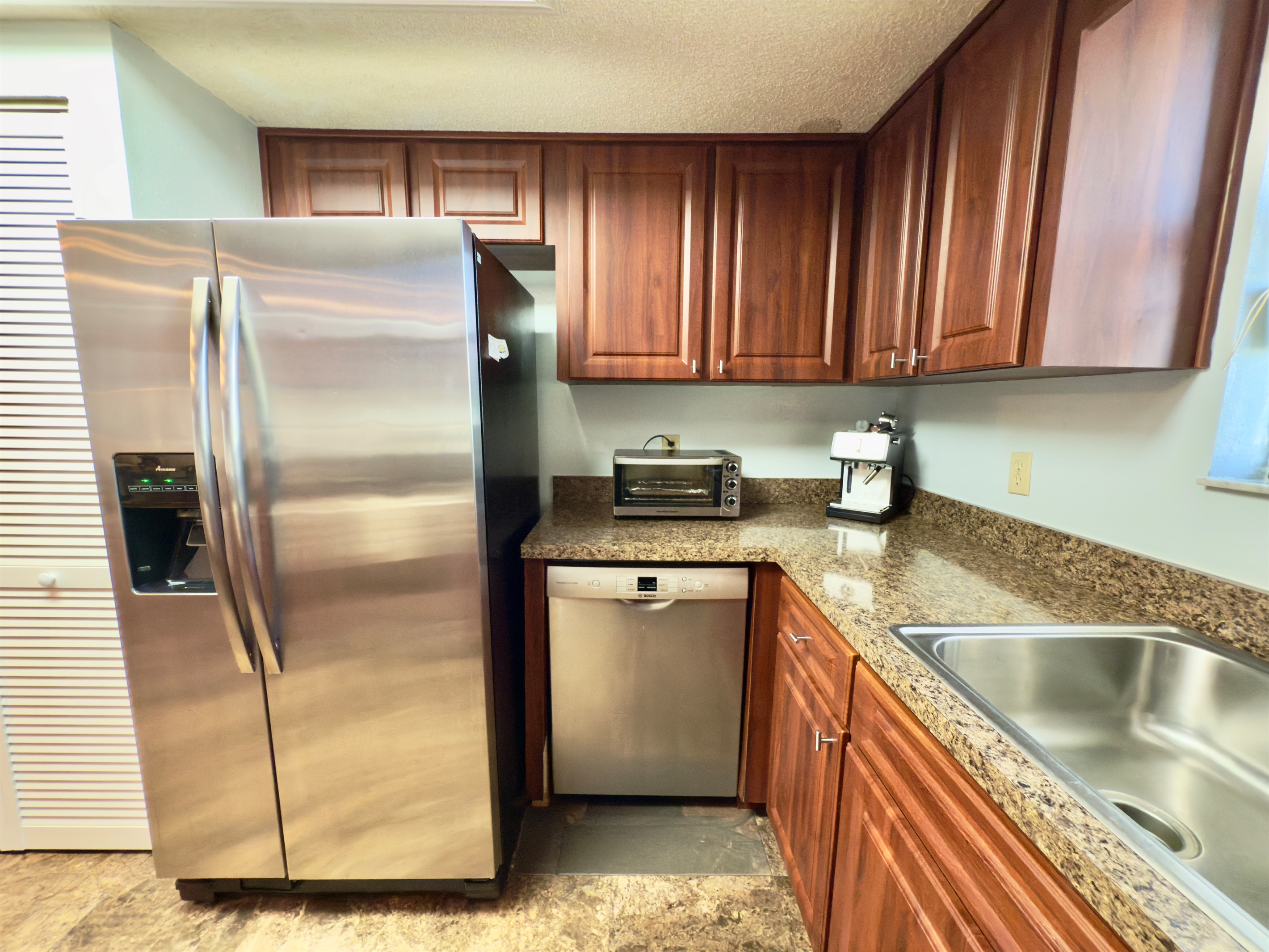 This stylishly appointed galley-style kitchen blends rich, classic finishes with modern amenities to create the perfect space for preparing meals.