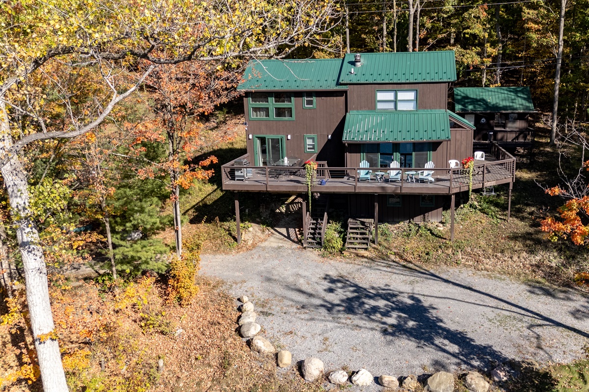 Front view of the cabin showing large deck and lake-access driveway.
