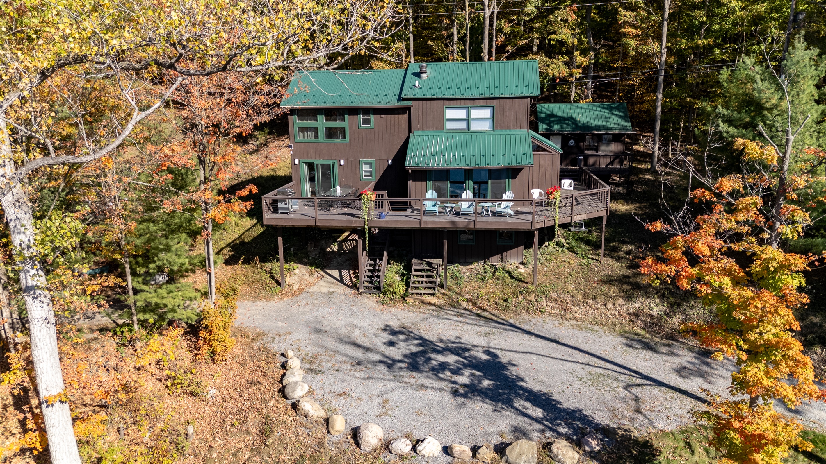 Front view of the cabin showing large deck and lake-access driveway.