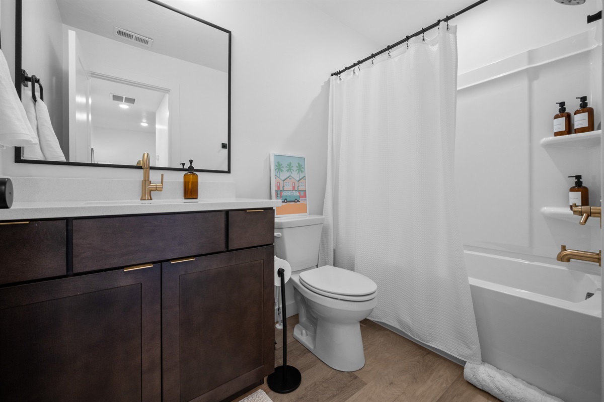 Full bathroom with tub/shower combo and modern design.