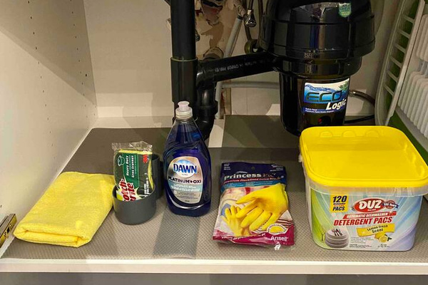 Under the kitchen sink are cleaning supplies.