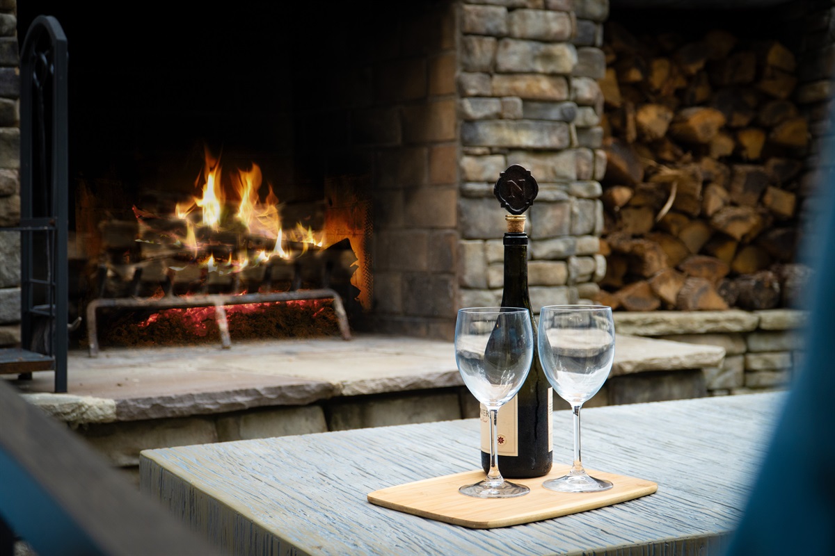 Relax by the outdoor fireplace, an inviting spot to gather, share stories, and take in the peaceful lake views.