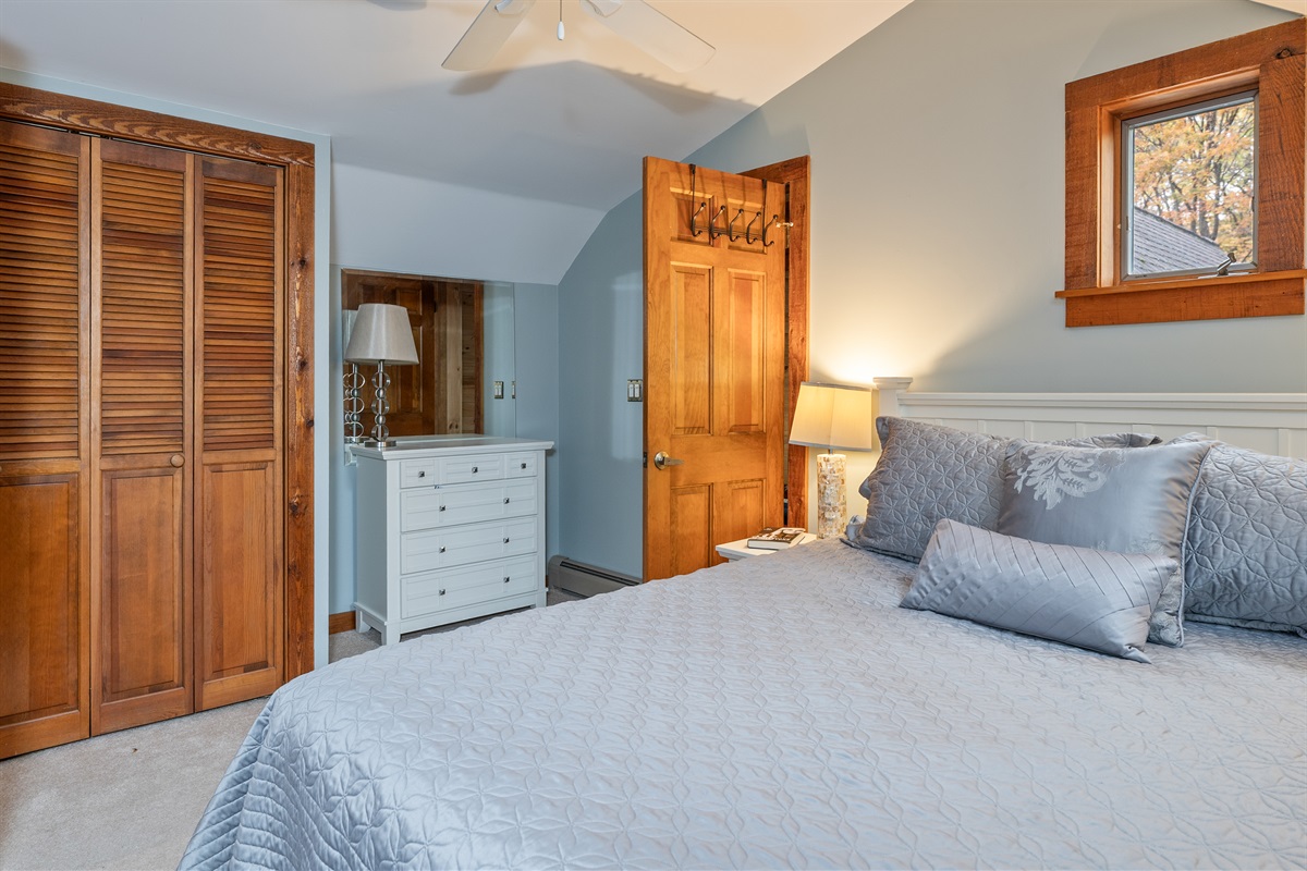 Bright and cozy primary bedroom featuring a queen bed and rustic charm.