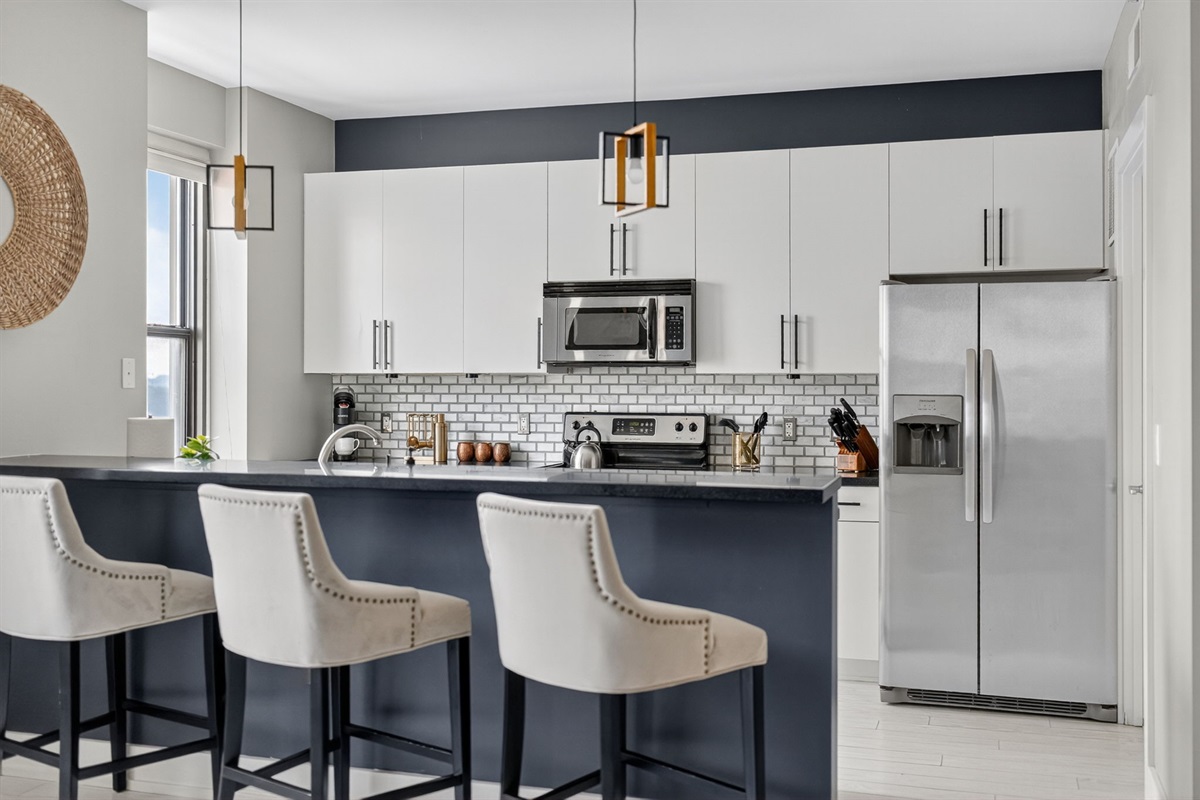 Cook with ease using stainless steel appliances, ample cabinetry, and generous counter space in this contemporary kitchen.