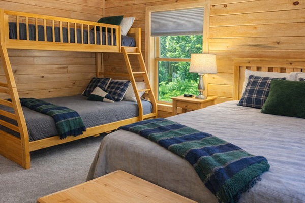 Spacious upstairs bunk room featuring a queen bed and twin-over-full bunk bed for flexible sleeping