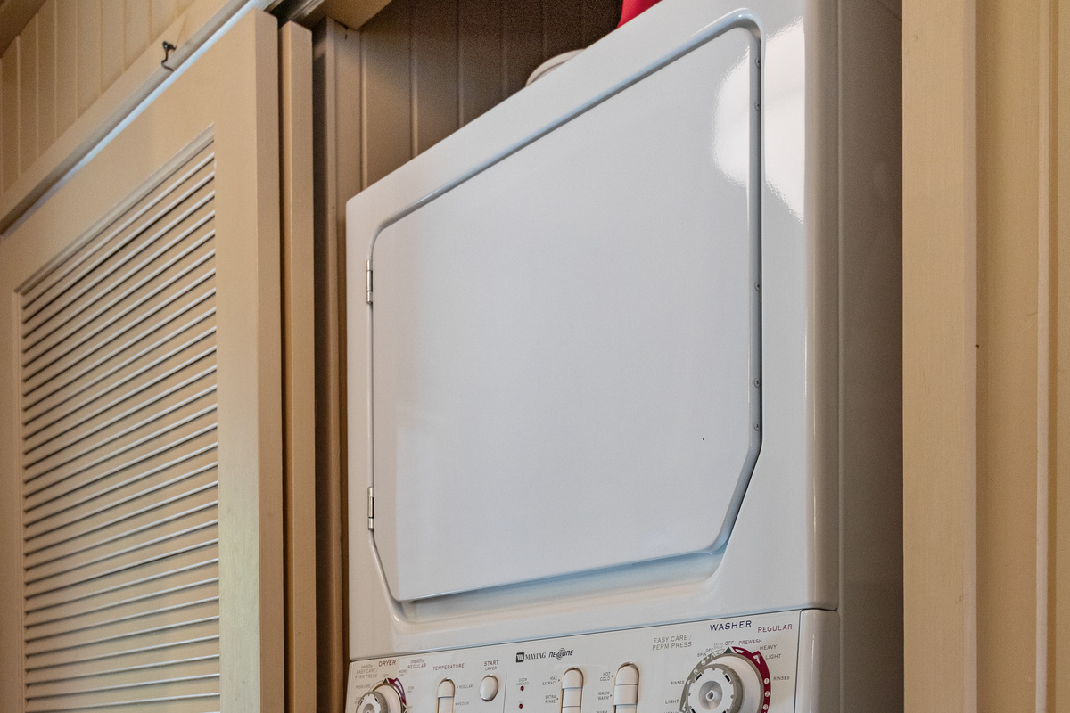 Conveniently tucked away just inside the entry, the laundry area keeps everyday necessities out of sight and the cottage feeling cozy.