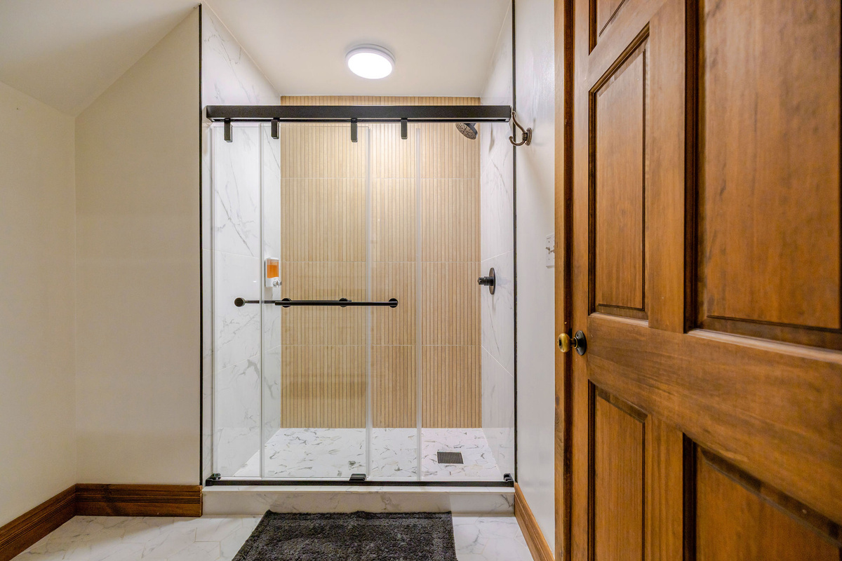 Enjoy a beautifully updated walk-in glass shower in the shared upstairs bathroom, thoughtfully designed for guests staying in Bedrooms 2–4.