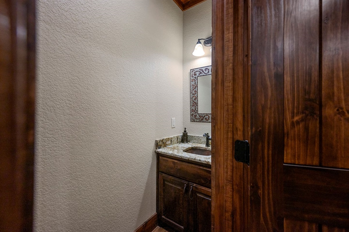 Half guest bathroom is conveniently located off the entryway