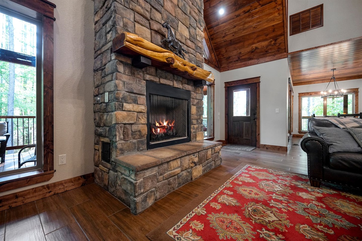 Stone fireplace w/rustic wooden mantle and fireplace. Not to be used in summer