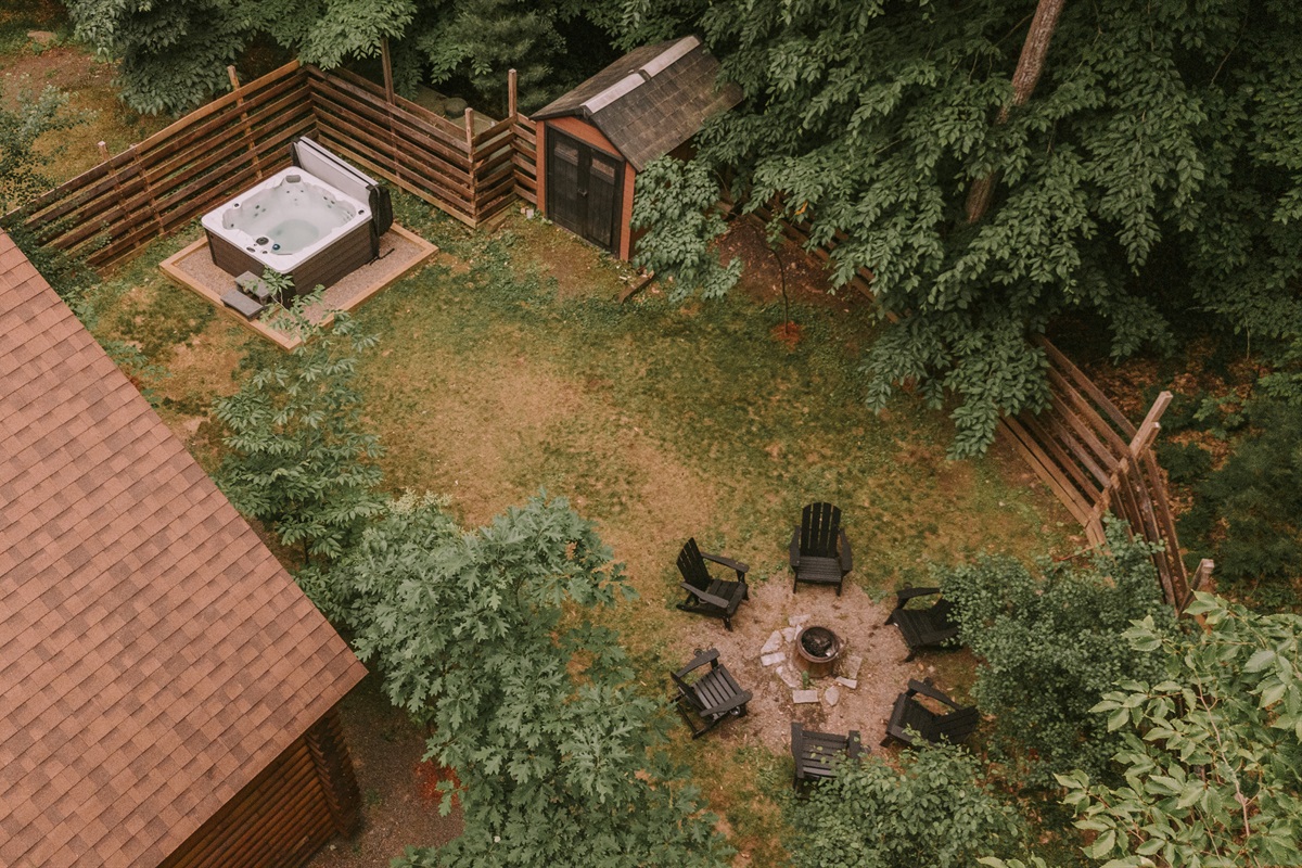 Aerial view of fenced yard, hot tub and firepit.
