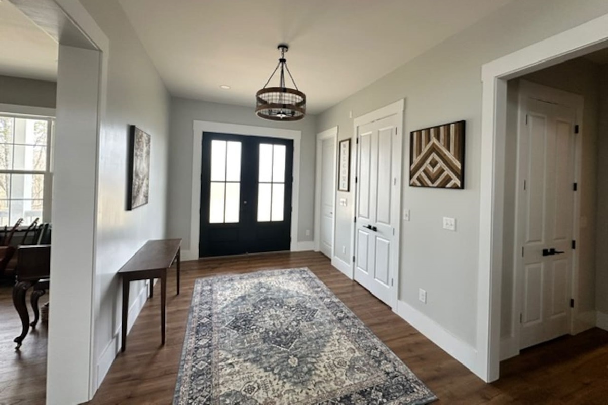 Our front doors open toward the grand staircase & open living room/kitchen area, with the library/music room on the right when you enter. The hallway on the opposite side leads to an extra full bath, laundry, & a second master bedroom door.