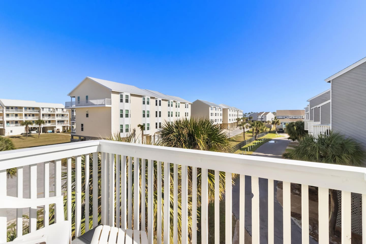 Find a calmer view from the guest balcony &mdash; looking inland over the community, coffee in hand, nothing competing for attention.