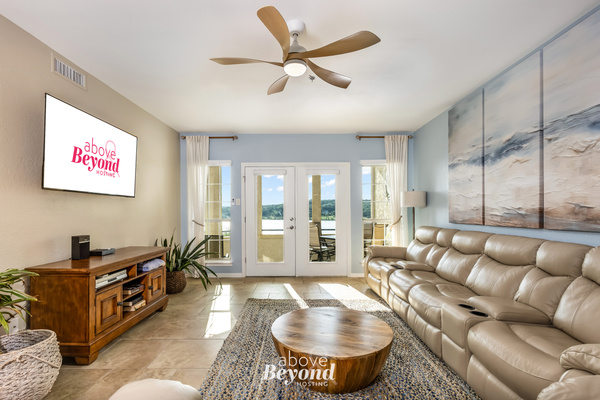 Spacious living room with comfortable seating, natural light, and access to the outdoor balcony.
