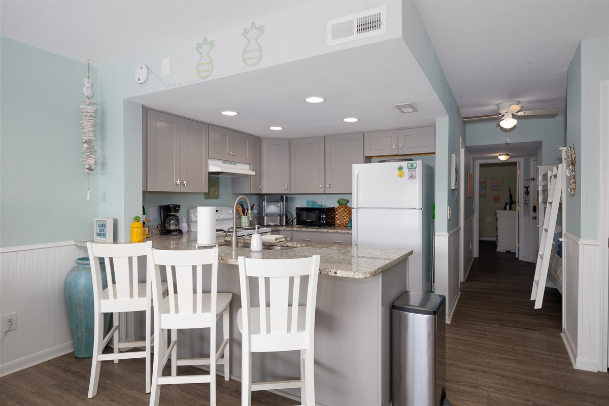 Updated kitchen with granite counters, ample storage, and a convenient breakfast bar overlooking the hallway