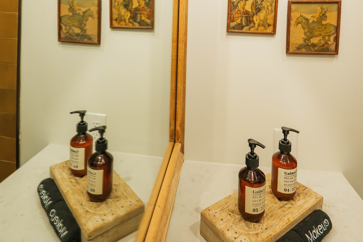 A closer look at the Corral Suite vanity — modern Western fixtures, a lit mirror, and curated bath amenities, all en-suite.