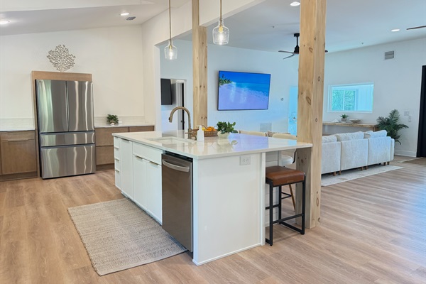 Open concept luxury living featuring one of two 85" smart TVs at the home