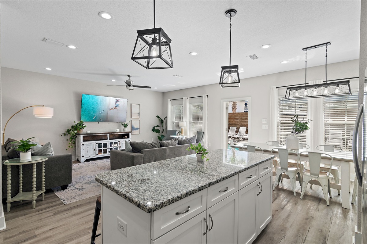 The open-concept living area includes a kitchen island, dining space, and kitchen.