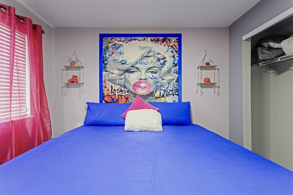 Bright and airy bedroom with a comfortable king-size bed and colorful decor. Perfect for a restful night's sleep.