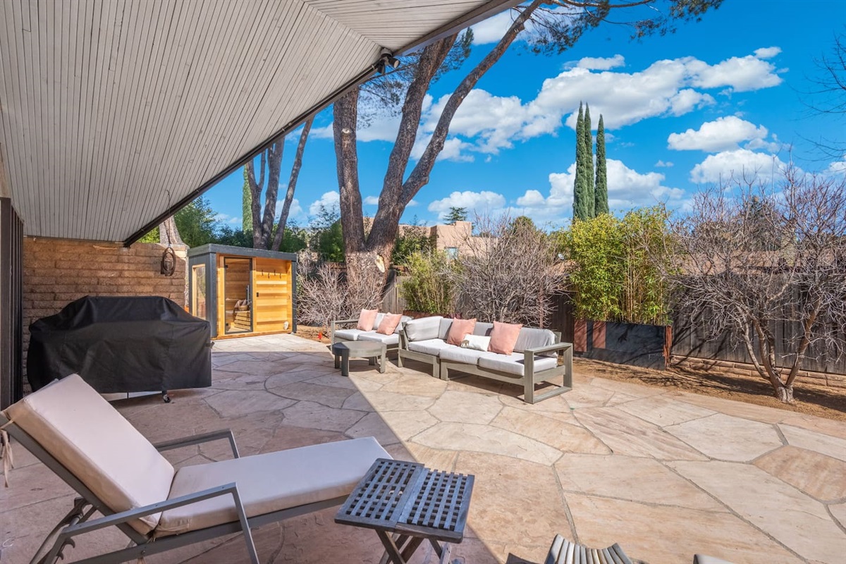 Private covered patio with outdoor seating, grill, sauna, and a spacious stone courtyard perfect for relaxing.