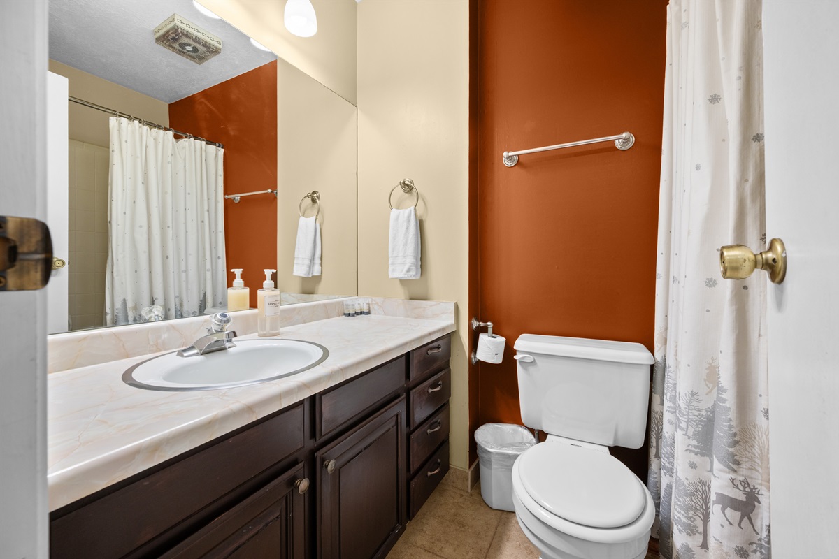 Full bathroom with shower/tub combination, vanity, and fresh towels provided.