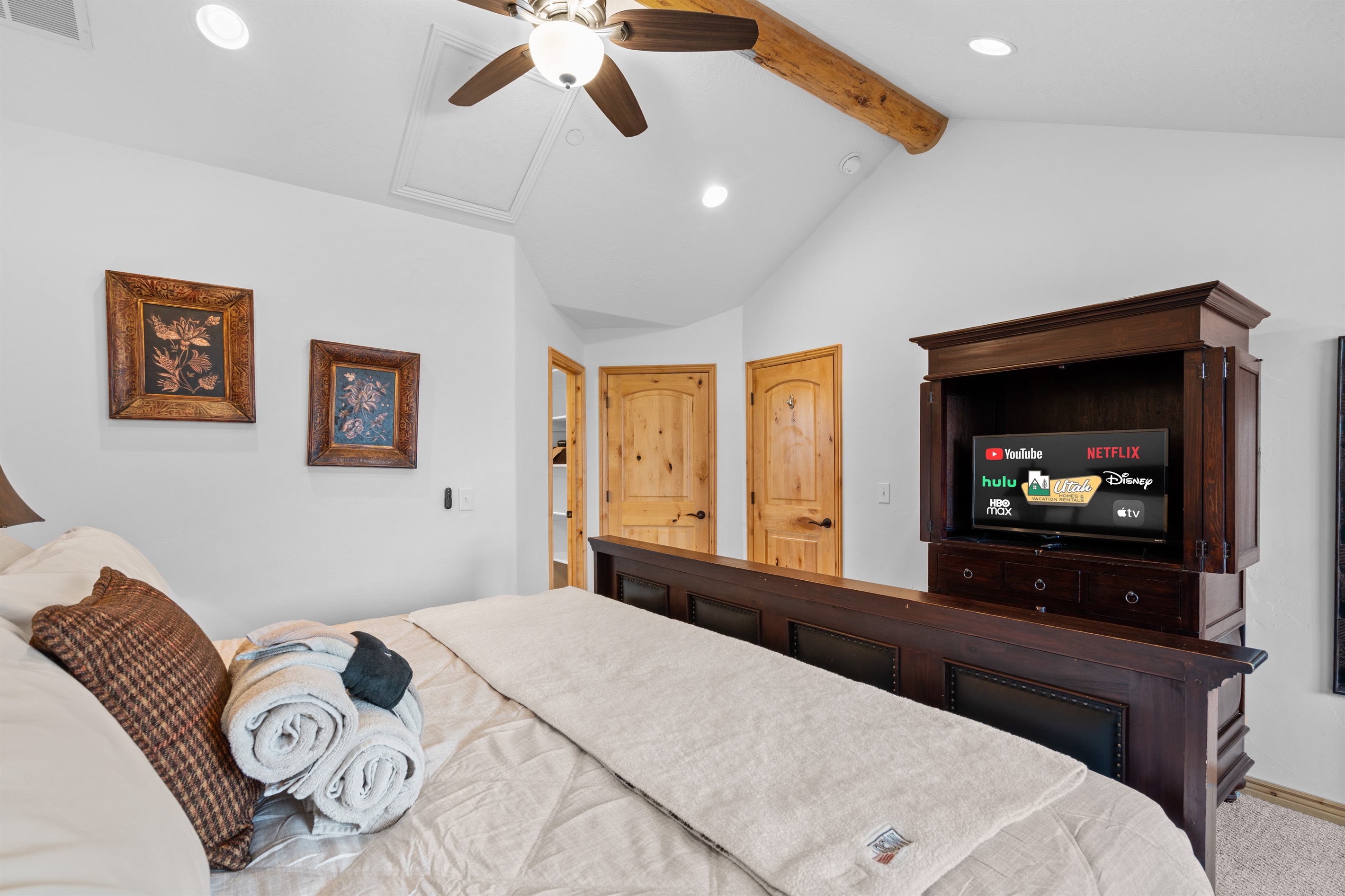 Inviting primary bedroom with plush bedding, vaulted ceilings, and a Smart TV for relaxed evenings.