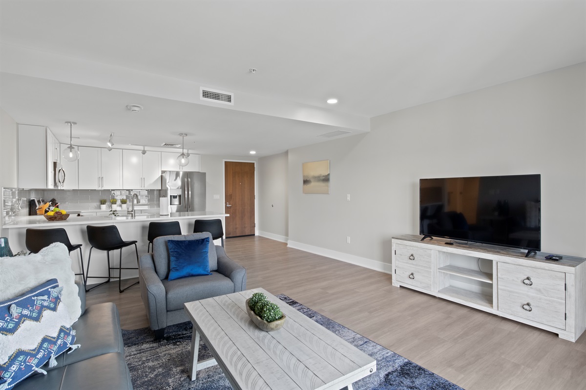 Enjoy spacious living with natural light flooding into this cozy living room, featuring stylish décor, a plush sofa, and a perfect spot to relax and unwind.