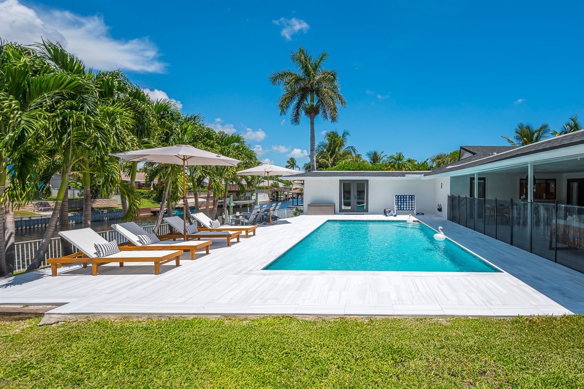 Spend your days lounging by the shimmering pool, dining al fresco under the covered patio, and unwinding in stylish outdoor living spaces—all set against a serene lakefront backdrop with private dock access