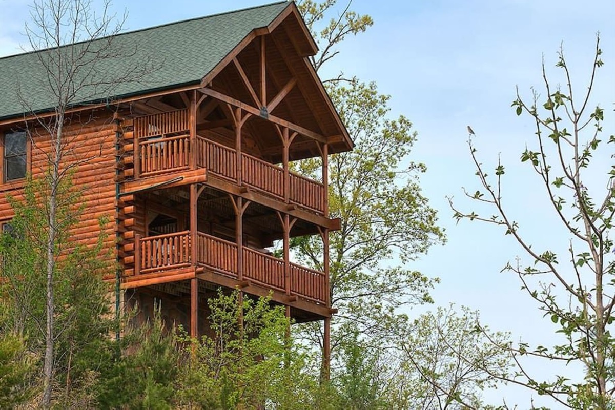 - Two-story log cabin featuring double balconies and forest surroundings   - Enjoy mountain breezes and panoramic views from every deck level   - Authentic Smoky Mountain charm with peaceful woodland scenery
