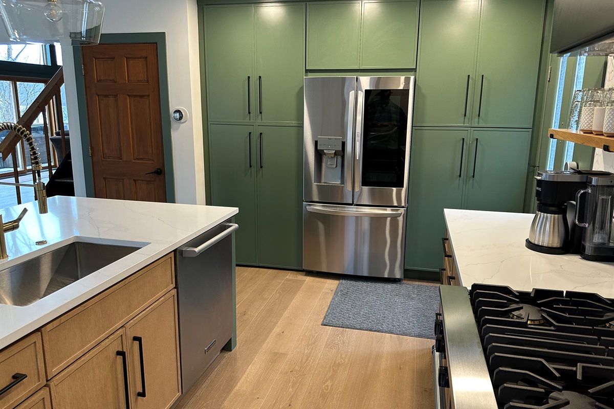 LG Washtower laundry unit is in the cabinet to the left of the fridge.