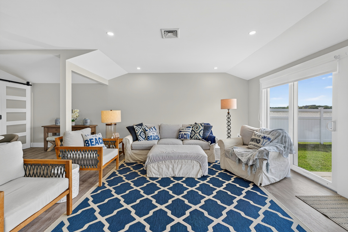 Elegant open-concept living room with cozy furnishings and panoramic waterfront scenery.