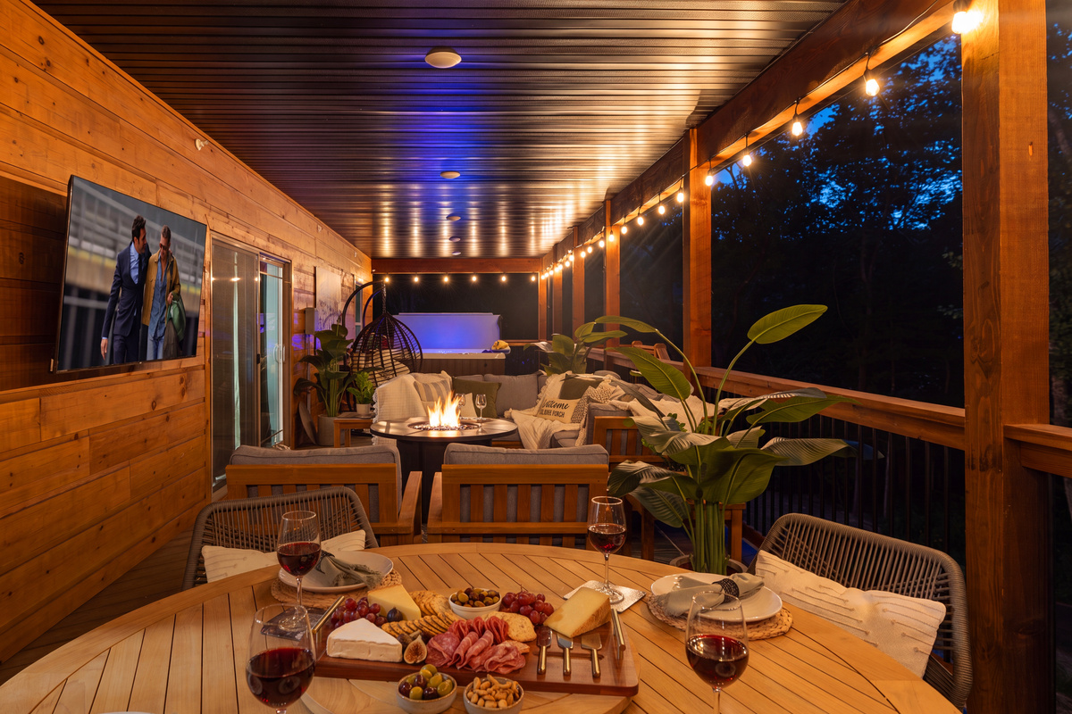 Warm lights and a late-night board on the deck table.
